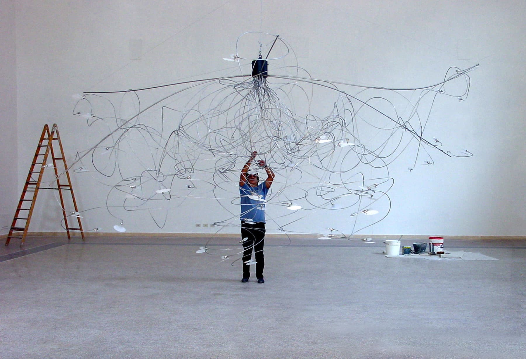 <p>Enzo Catellani riceve la commissione di realizzare un enorme lampadario speciale (pezzo unico) per la Sala Dante di Palazzo Poli Fontana di Trevi a Roma, attuale sede dell’Istituto Centrale per la Grafica; lo studio di quella lampada pose le basi per l’elaborazione del prototipo di ciò che sarebbe diventata la creazione più nota e distintiva della produzione di Enzo Catellani: “Fil de Fer”</p>