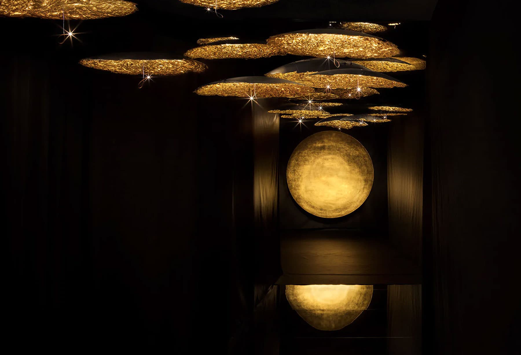 <p>“Resonance” di Enzo Catellani è un percorso scenografico di luci e suoni che coinvolge ed emoziona, grazie a dischi rivestiti in foglia oro illuminati da micro LED che si alternano a diverse altezze e dimensioni. Con questo progetto del Fuorisalone milanese, Enzo Catellani crea un dialogo coerente tra musica, luci e penombre: è un’atmosfera affascinante che conduce il visitatore alla scoperta della luce, sotto una ‘nuova luce’.</p>